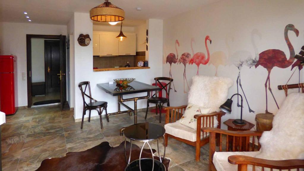 uma sala de estar com uma parede com flamingos pintados nela em Haus der 5 Kontinente em Böbrach