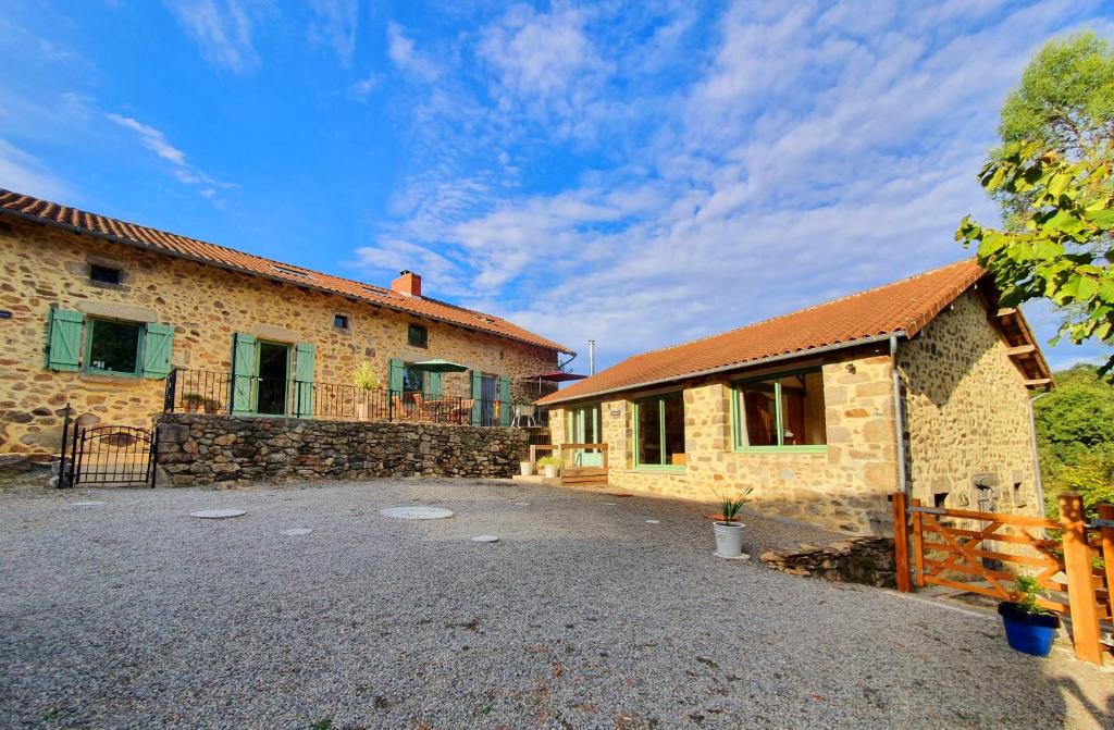 un grand bâtiment en pierre avec une clôture à côté dans l'établissement La Porcherie, à Saint-Mathieu