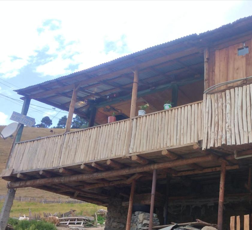 een houten huis met een balkon erboven bij guest house "BETQIL" adishi in Adishi