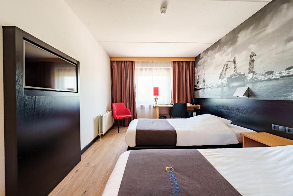 a hotel room with two beds and a desk at Bastion Hotel Rotterdam Zuid in Rotterdam