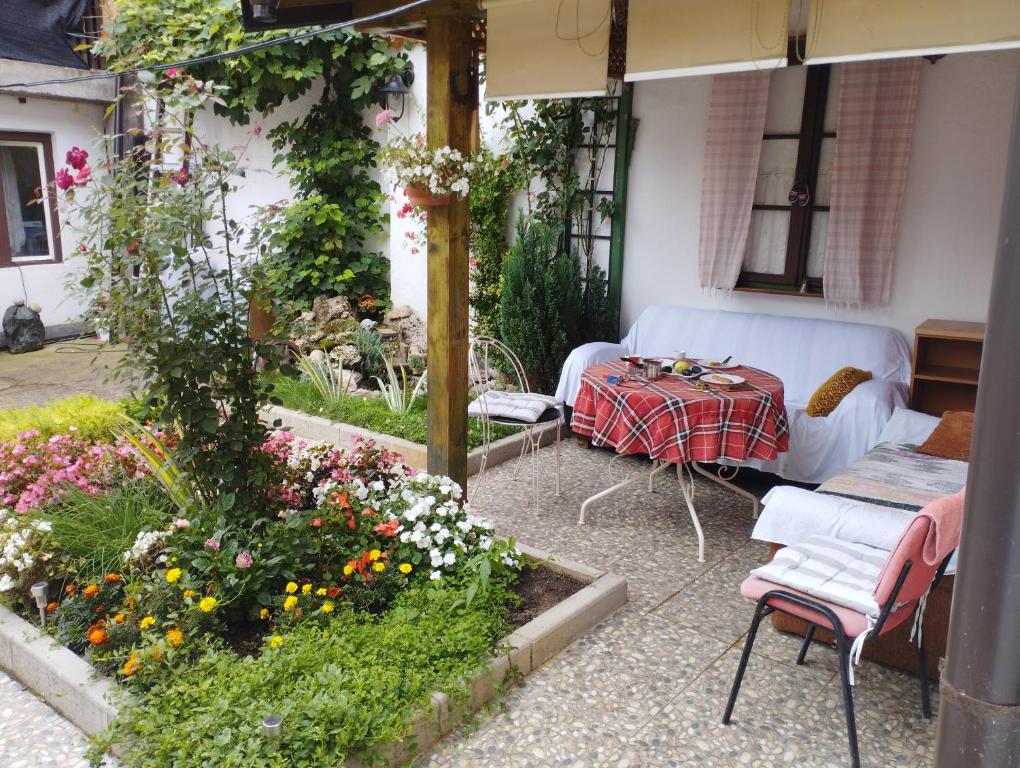un jardín con sofá, mesa y flores en Accordeon en Visoko
