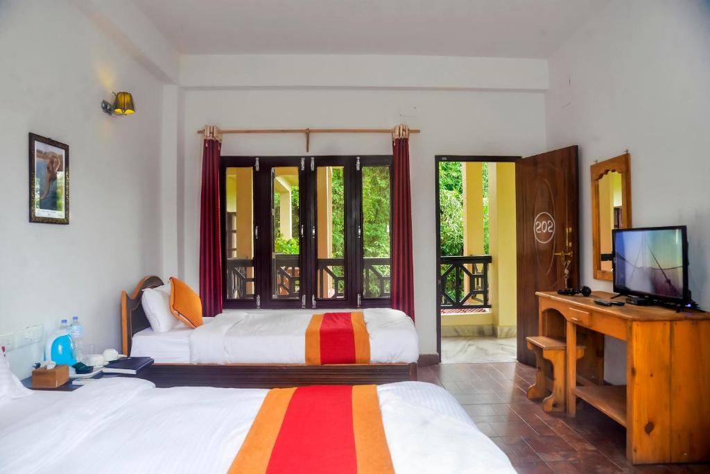 索拉哈Chitwan Park Village的一间卧室配有一张床,并在一间客房内配有电视。