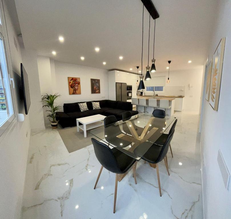 comedor y sala de estar con mesa de cristal en Apartamento Casa Blanca, en Las Palmas de Gran Canaria
