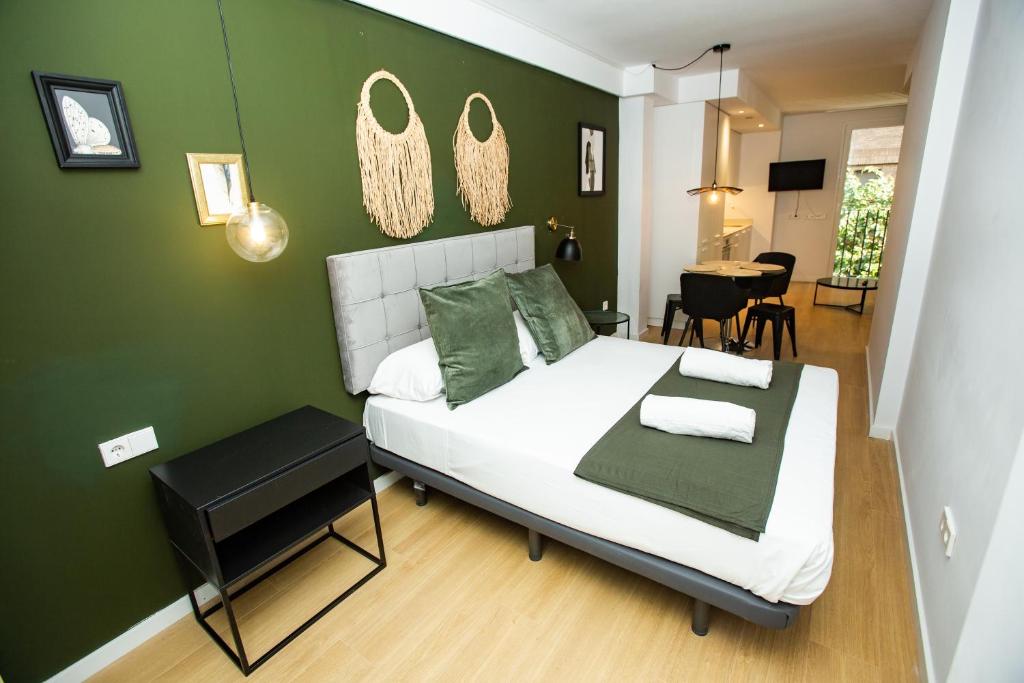 a bedroom with a bed and a green wall at Total Valencia Torres de Quart in Valencia