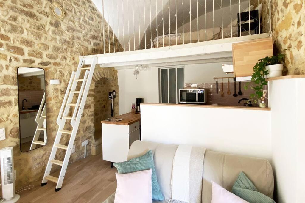 ein Wohnzimmer mit einem Sofa und einem Hochbett in der Unterkunft La Bergerie de Carmen in Mornas