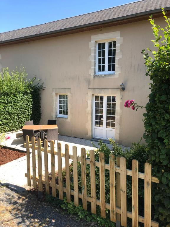 ein Haus mit einem Holzzaun davor in der Unterkunft Normandia Parfum de pommes et d'histoire in Nonant