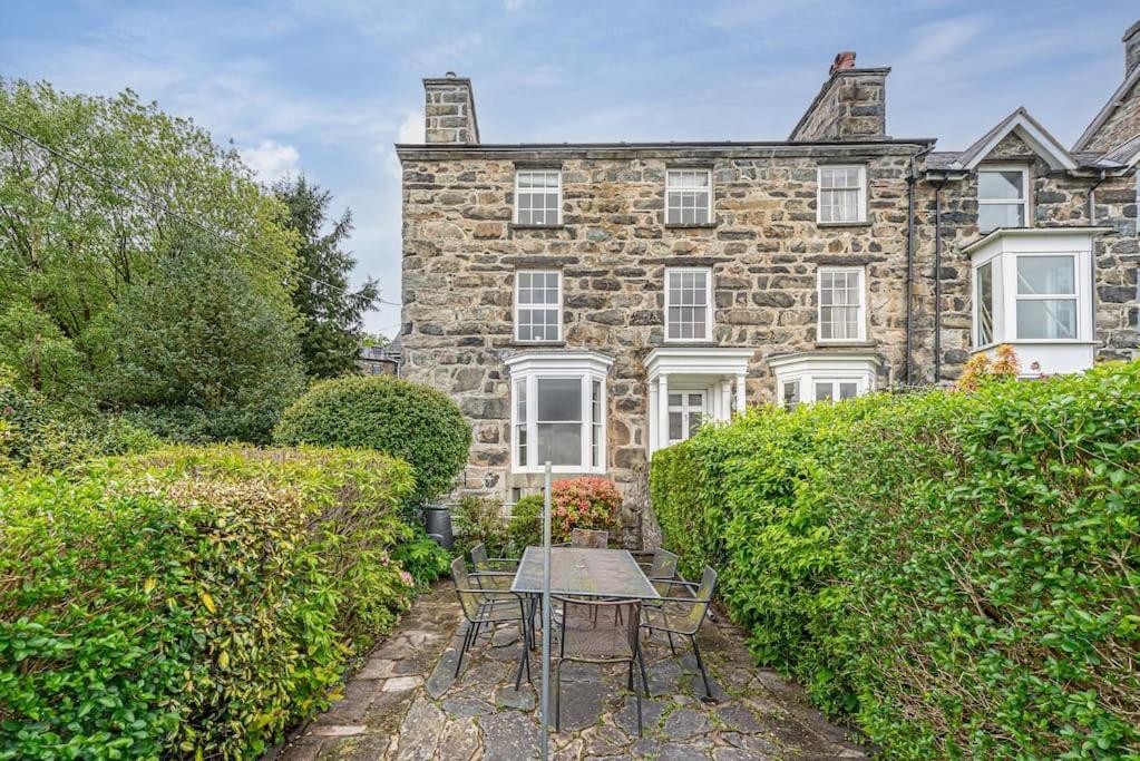 een stenen huis met een tafel en stoelen ervoor bij Dolgellau Townhouse 2 Minutes to Town & Mountains in Dolgellau