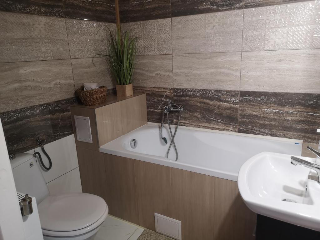 uma casa de banho com uma banheira, um WC e um lavatório. em Apartament fort Owcza Góra na poddaszu em Klodzko