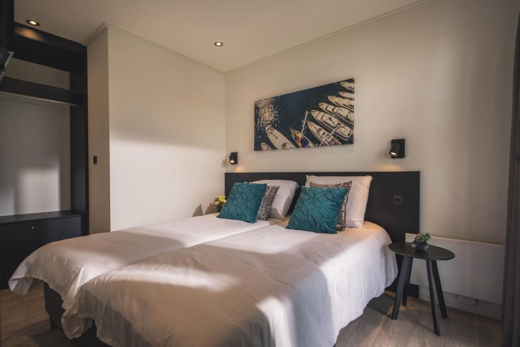 - une chambre avec un grand lit et des oreillers bleus dans l'établissement MarinaPark Bad Nederrijn, à Maurik