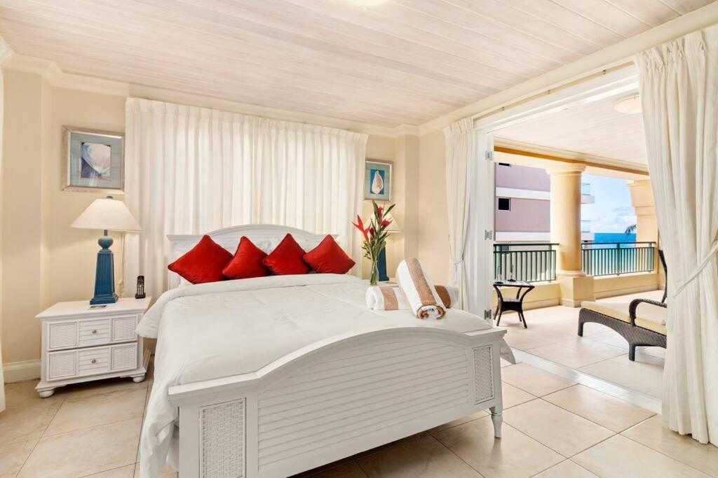 a white bedroom with a large bed and a balcony at White Sands Beach Villas - Villas N- Lovely 1 Bed Condo in Christ Church