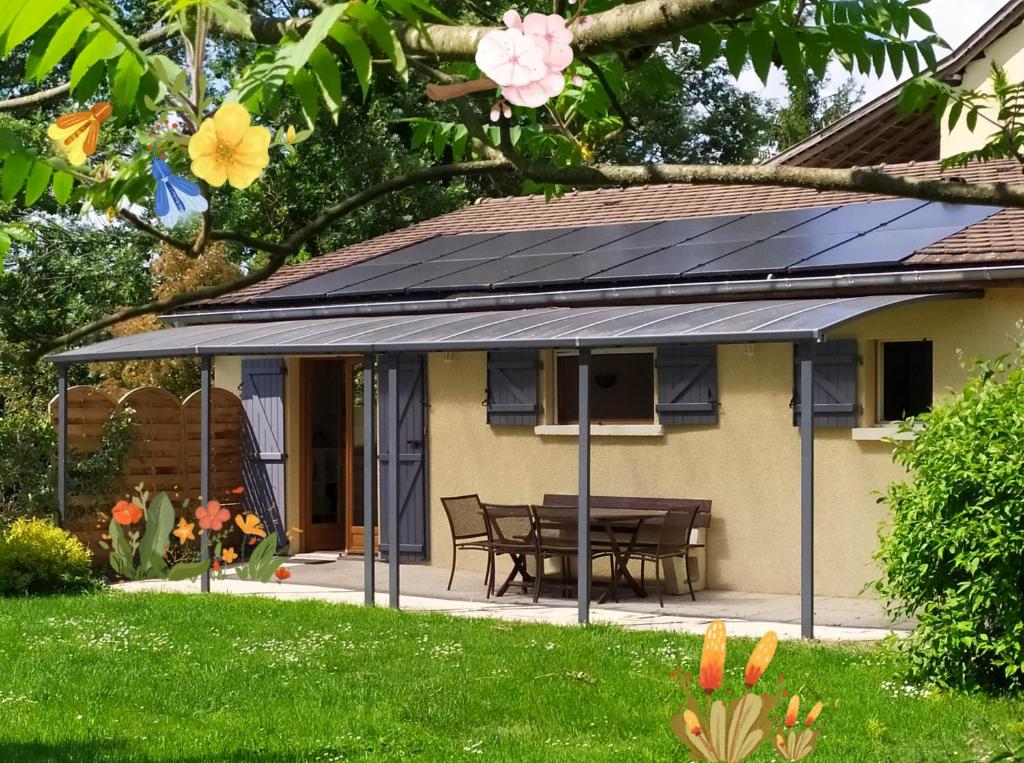 einen Wintergarten mit einem Dach mit Sonnenkollektoren darauf in der Unterkunft Gîte De Séjour Les Sables in Brégnier-Cordon