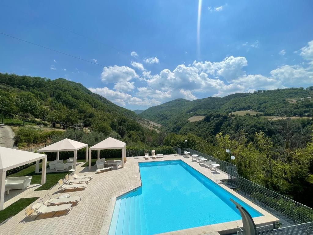 uma piscina com montanhas ao fundo em Hotel Ristorante Tre Lanterne & SPA em Acquasanta Terme