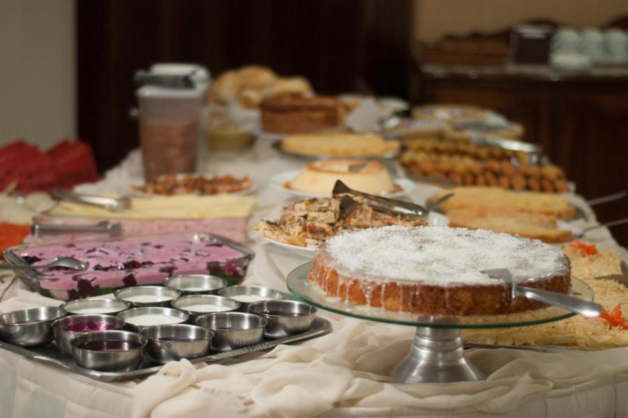 Mariano Palace Hotel في كامبيناس: طاولة بها العديد من الأنواع المختلفة من الكعك والفطائر