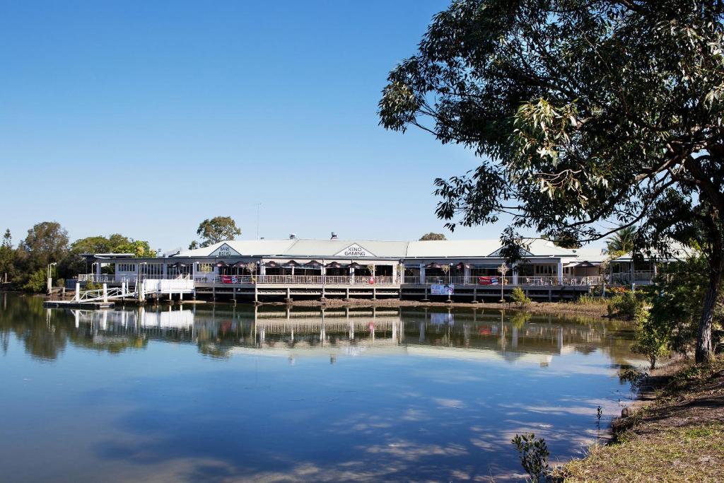 a large building sitting on the side of a lake at Nightcap at Waterfront Hotel in Maroochydore