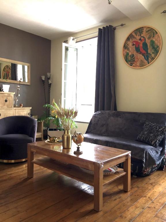 un salon avec un canapé et une table basse dans l'établissement appartement cocooning,proche centre et gare, à Caen