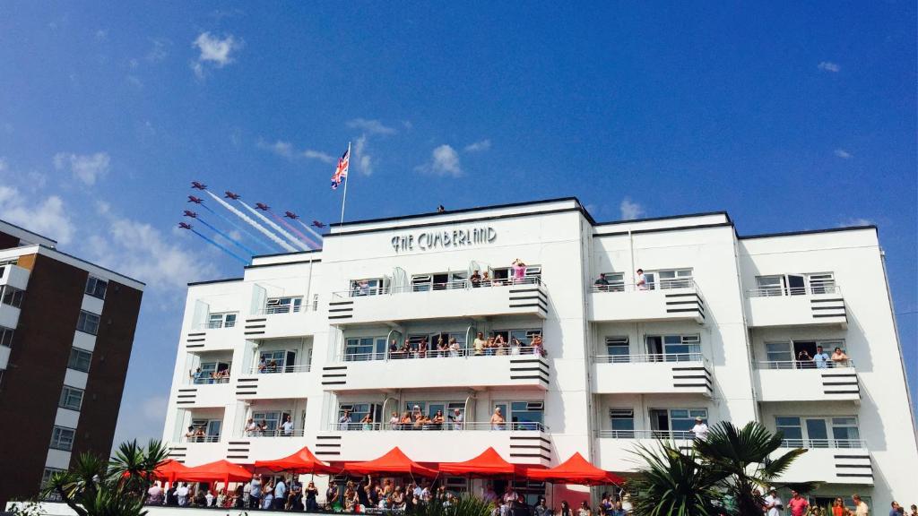 a white building with a flag on top of it at Cumberland Hotel - OCEANA COLLECTION in Bournemouth