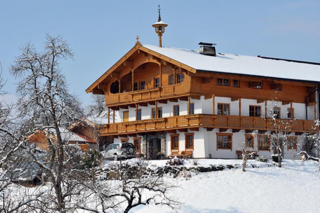 ein großes Holzhaus mit Schnee auf dem Dach in der Unterkunft Stegerbauer in Kirchbichl