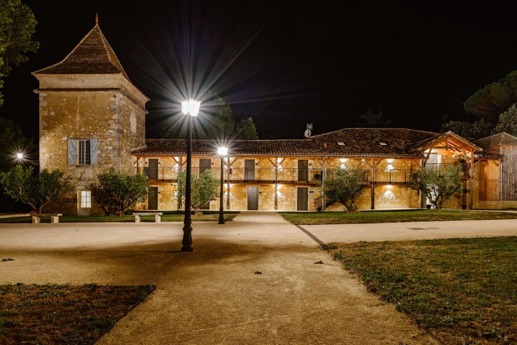 un bâtiment avec un éclairage de rue devant lui dans l'établissement Domaine de Boulouch, à Lectoure