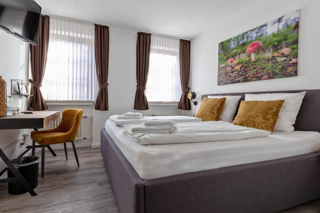 1 dormitorio con 1 cama grande, escritorio y ventanas en Hotel Restaurant Haus Vorst, en Tönisvorst