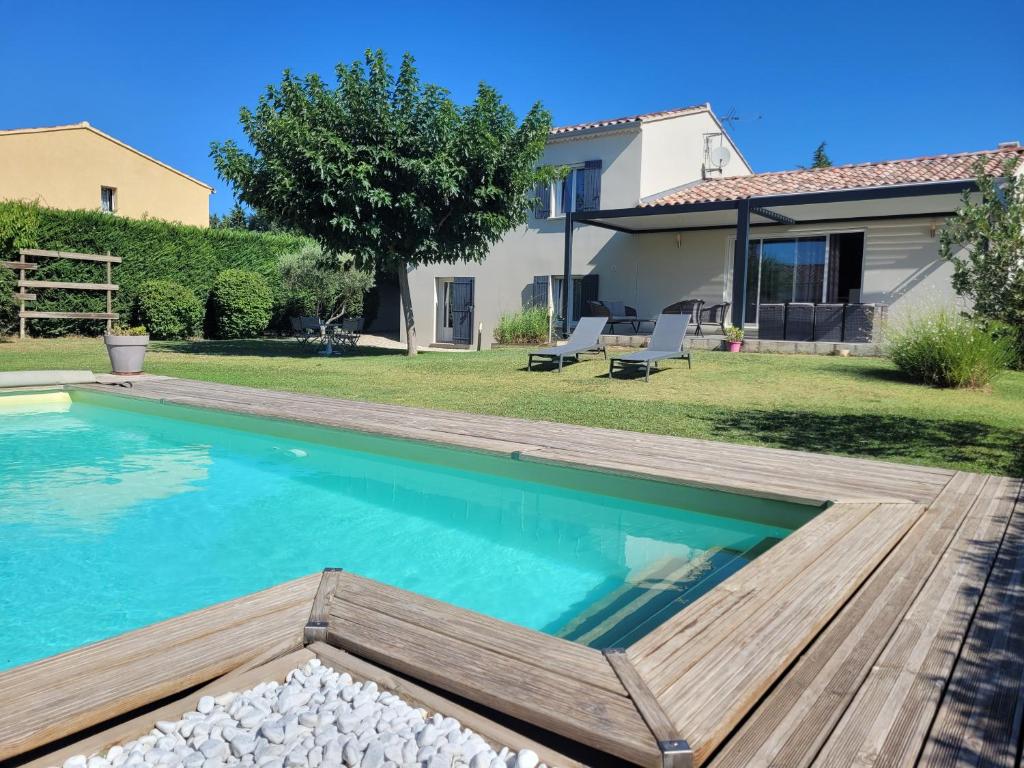 un patio trasero con piscina y una casa en Villa de la Capèra, en Camaret-sur-Aigues