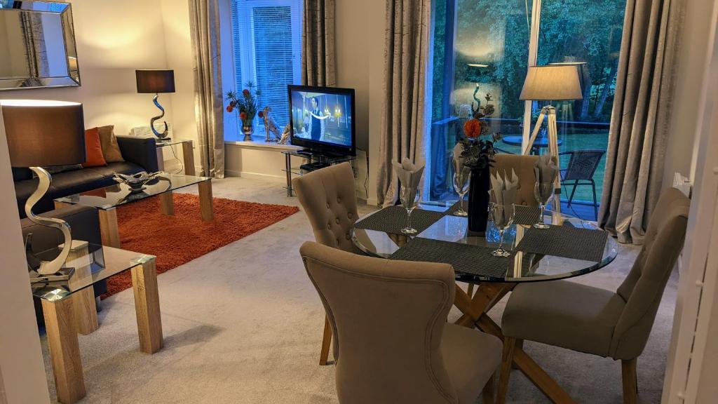 a living room with a glass table and chairs at Gleneagles Country Apartments in Auchterarder