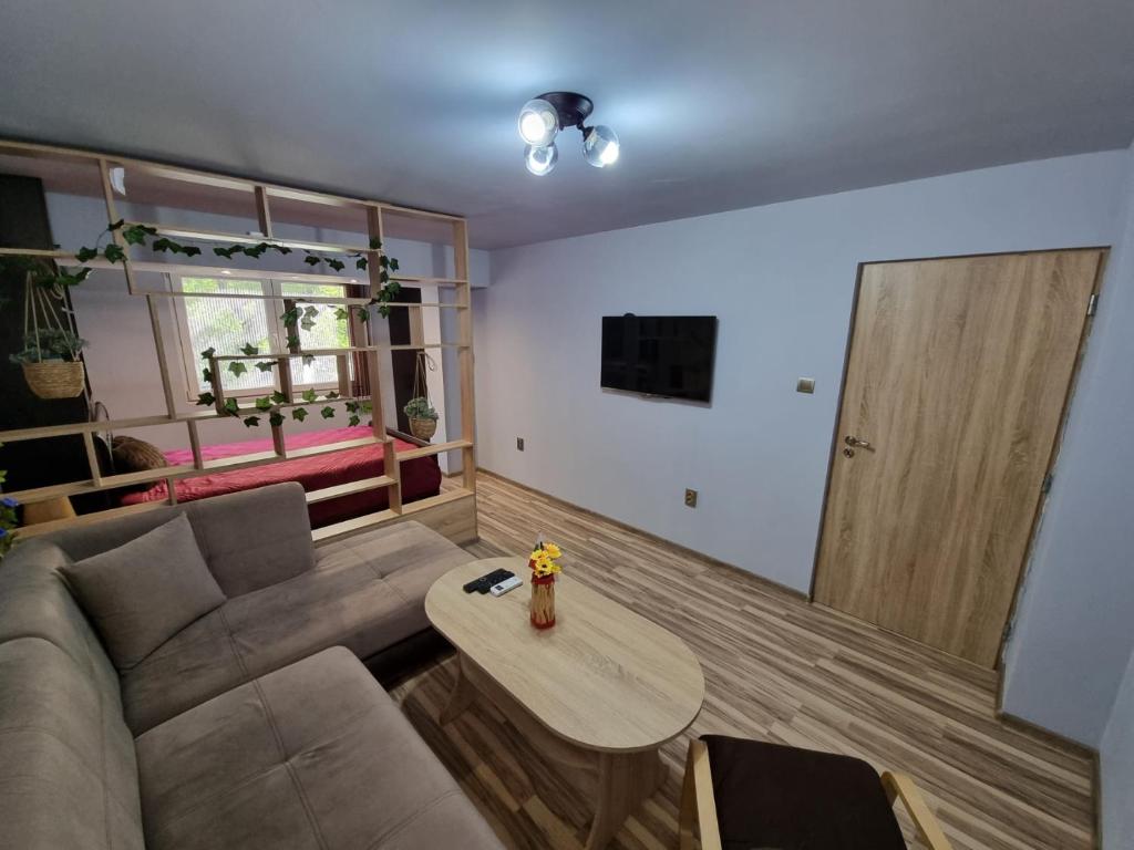 sala de estar con sofá y mesa en Бутиков Апартамент - Тракия, en Shumen