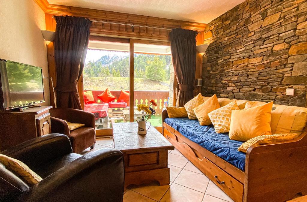 a living room with a couch and a stone wall at SkiMottaret in Méribel