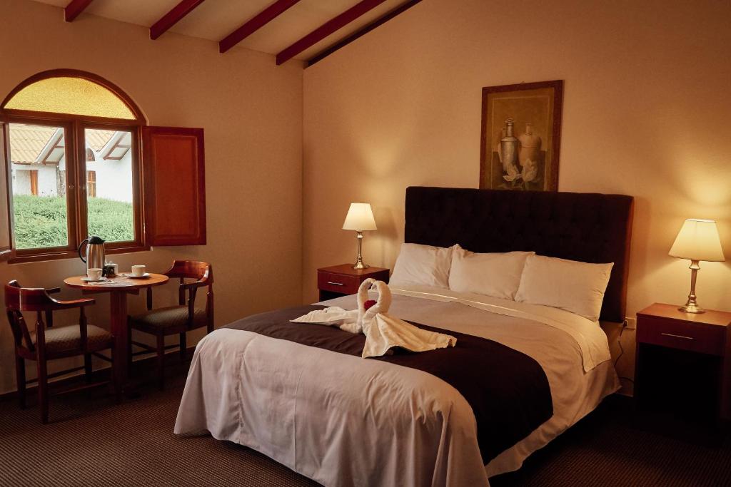 ein Hotelzimmer mit einem Bett und einem Bademantel. in der Unterkunft Casona Plaza Ecolodge Colca in Yanque