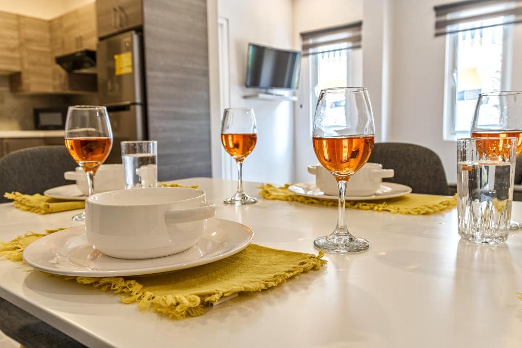 a table with two glasses of wine and a plate of food at Apt 27 CityLife Aruba in Oranjestad