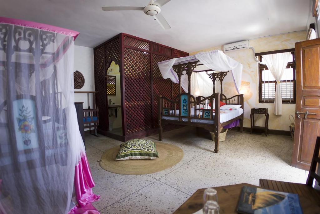 Habitación con dormitorio con cama y cortinas. en Zenji Hotel, en Zanzíbar