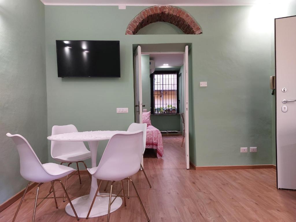 a dining room with a table and white chairs at 2 Via Fabio Mangone in Milan