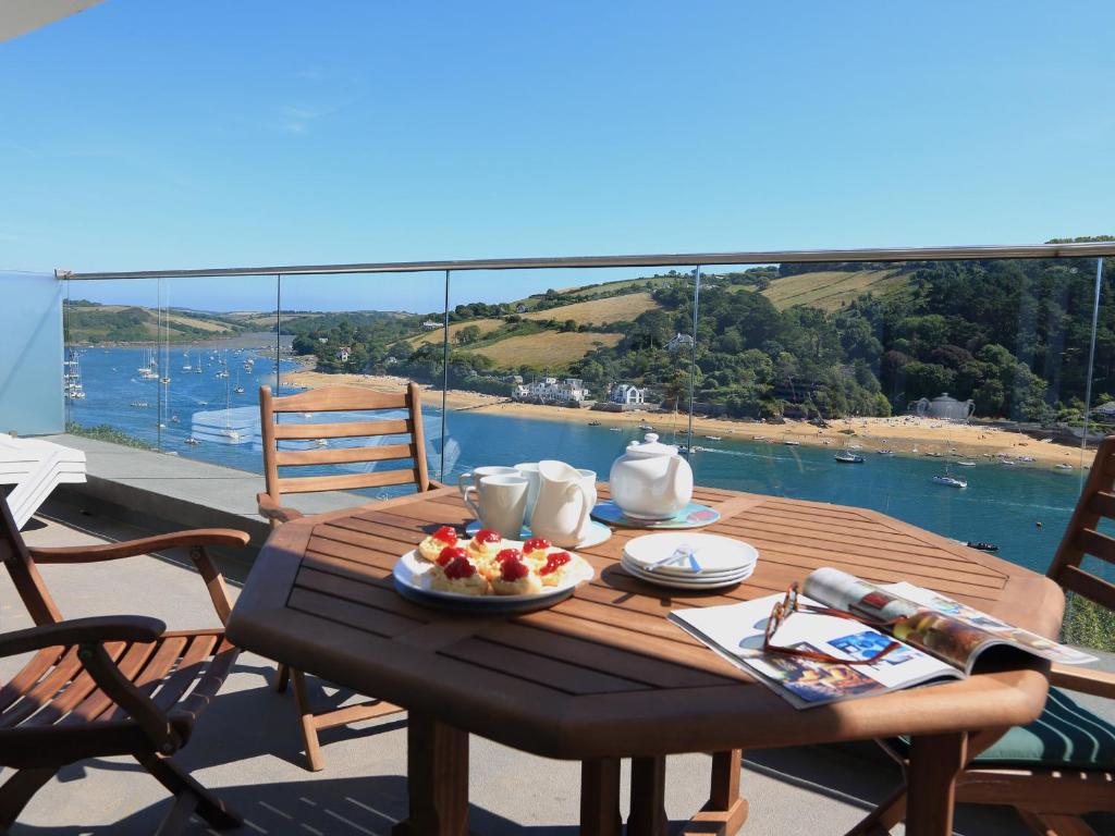 a wooden table with a plate of food on a balcony at 2 Poundstone Court in Salcombe