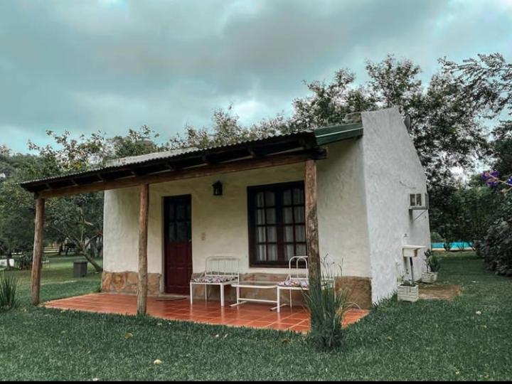 een klein huis met een patio in het gras bij EL PASO IBERA in Colonia Carlos Pellegrini
