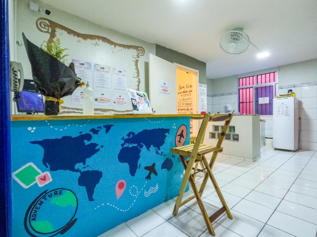 a classroom with a counter and a wooden chair at Aloha Hostel Pinhões in Fortaleza
