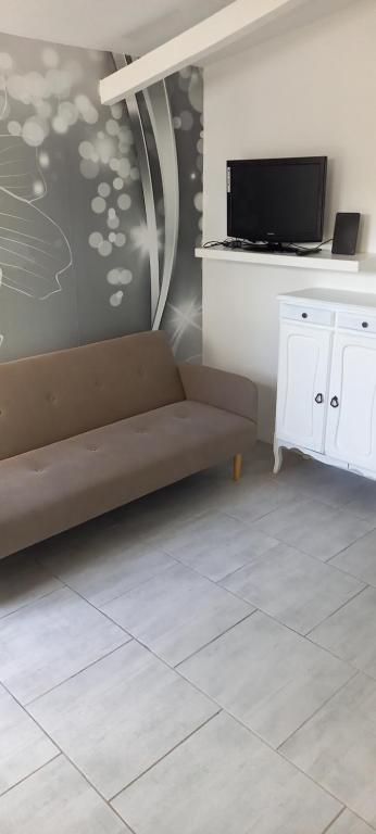 a living room with a couch and a tv at Studio in Sorgues