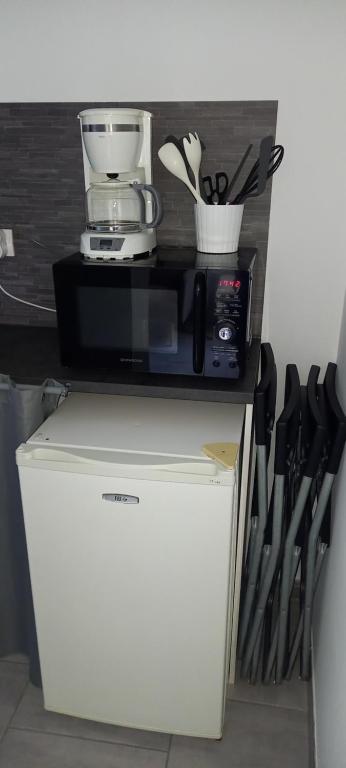 a blender on top of a refrigerator with knives at Studio in Sorgues