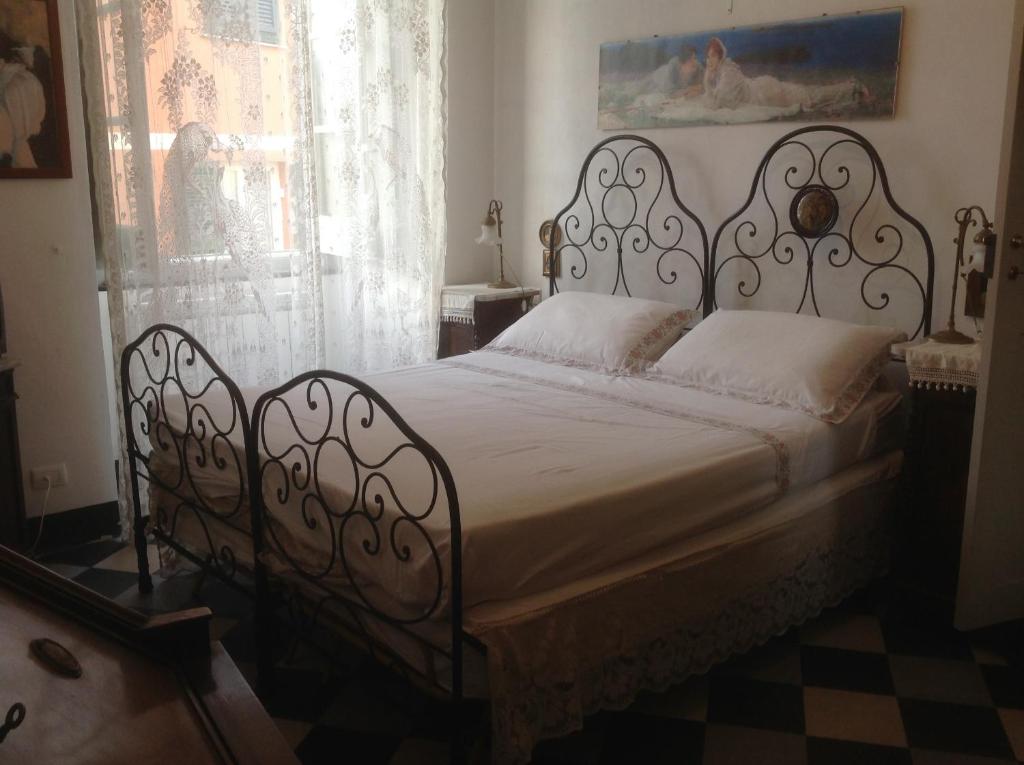 una camera con letto bianco e struttura in ferro battuto di Impero Luxury Apartment a Levanto