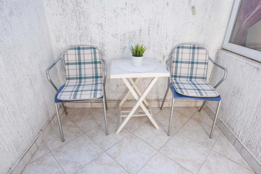 two chairs and a table with a plant on it at Apartments Ante in Pakoštane