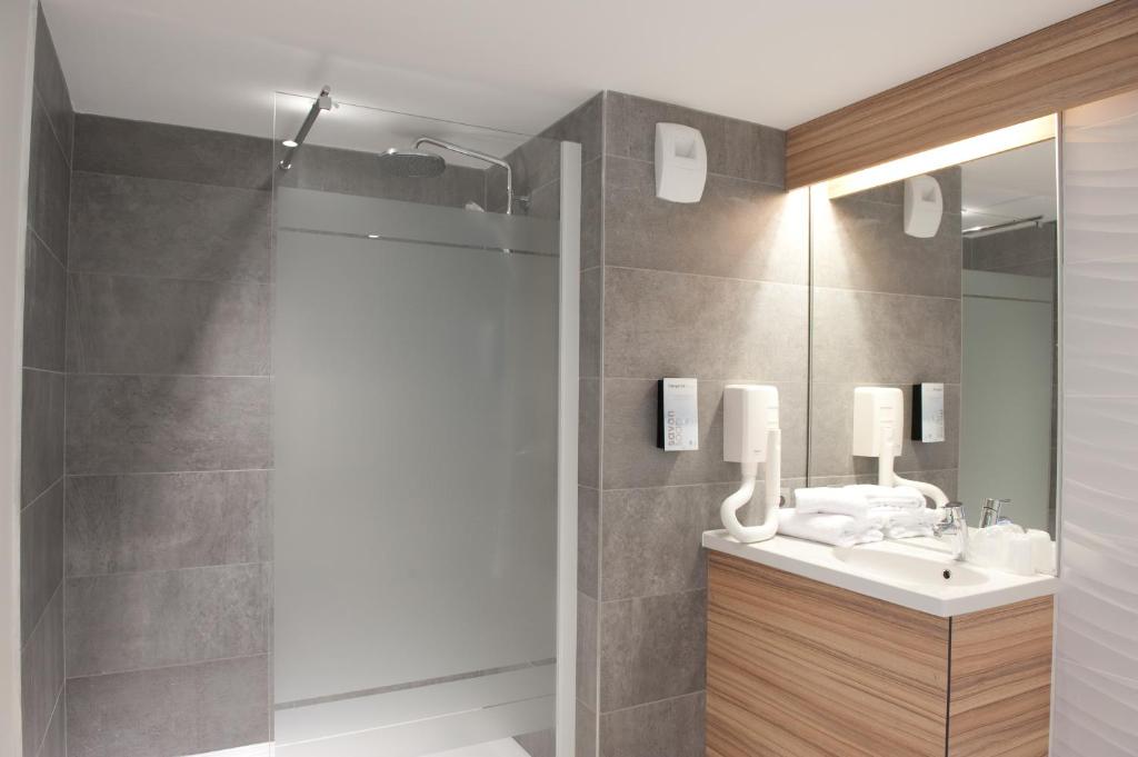 a bathroom with a shower and a sink and a mirror at Campanile Limoges Centre - Gare in Limoges
