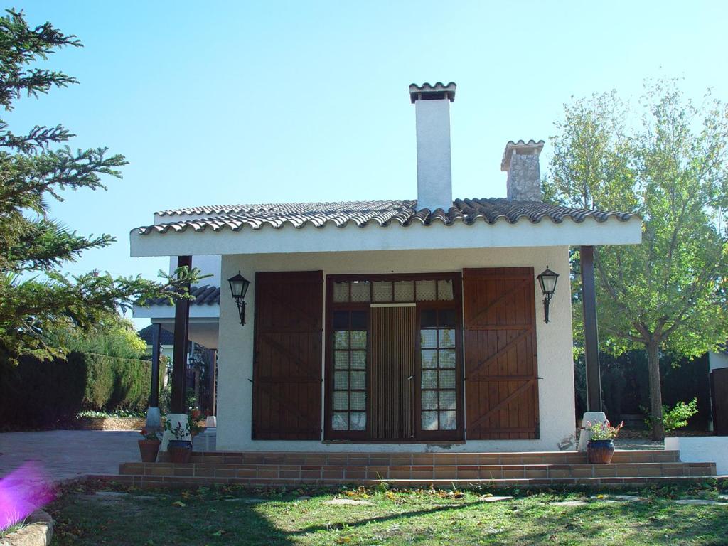 una pequeña casa con una puerta marrón en un patio en Casa Rural Eucaliptus, en Montferri