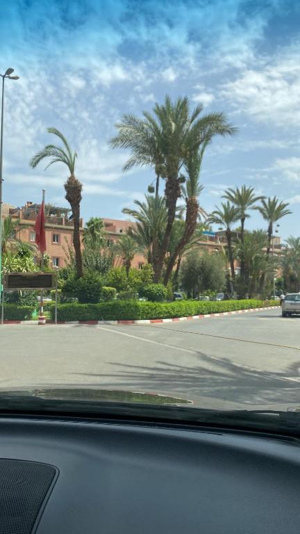 a view of a street with palm trees and a building at Riad Lyna in Marrakech