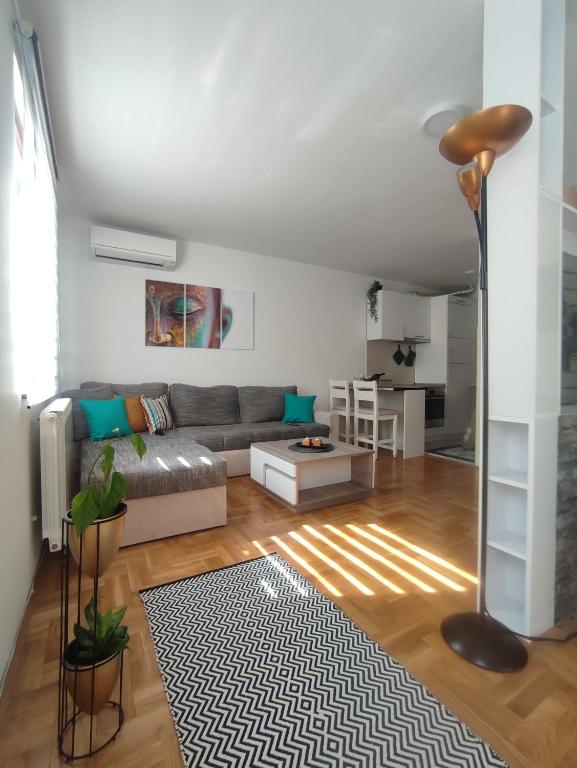 ein Wohnzimmer mit einem Sofa und einem Tisch in der Unterkunft Apartman Buda in Lukavica