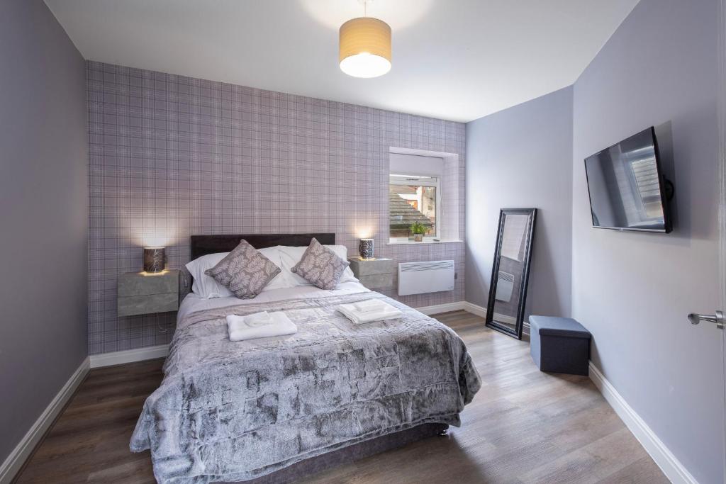 a bedroom with a large bed and a television at Ocean View Apartments - Chelsea in Blackpool