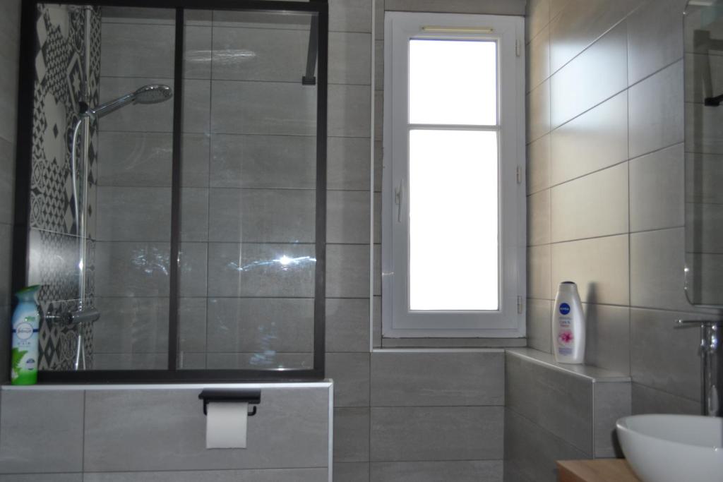 a bathroom with a shower and a sink and a window at L&#39;essentiel de Chartres in Chartres