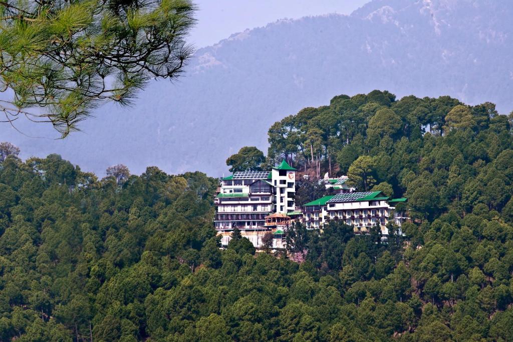 麦罗肯机Fortune Park Moksha, Mcleodganj - Member ITC Hotels' Group的森林中间的一座小山上的建筑