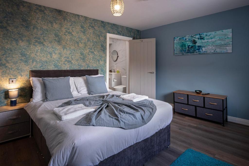 - une chambre avec un grand lit aux murs bleus dans l'établissement Ocean View Apartments - Soho, à Blackpool