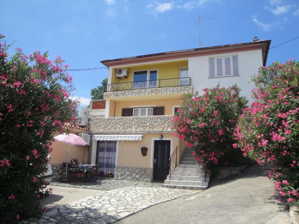 Casa con balcón y flores rosas en Apartments Vesna G., en Šilo