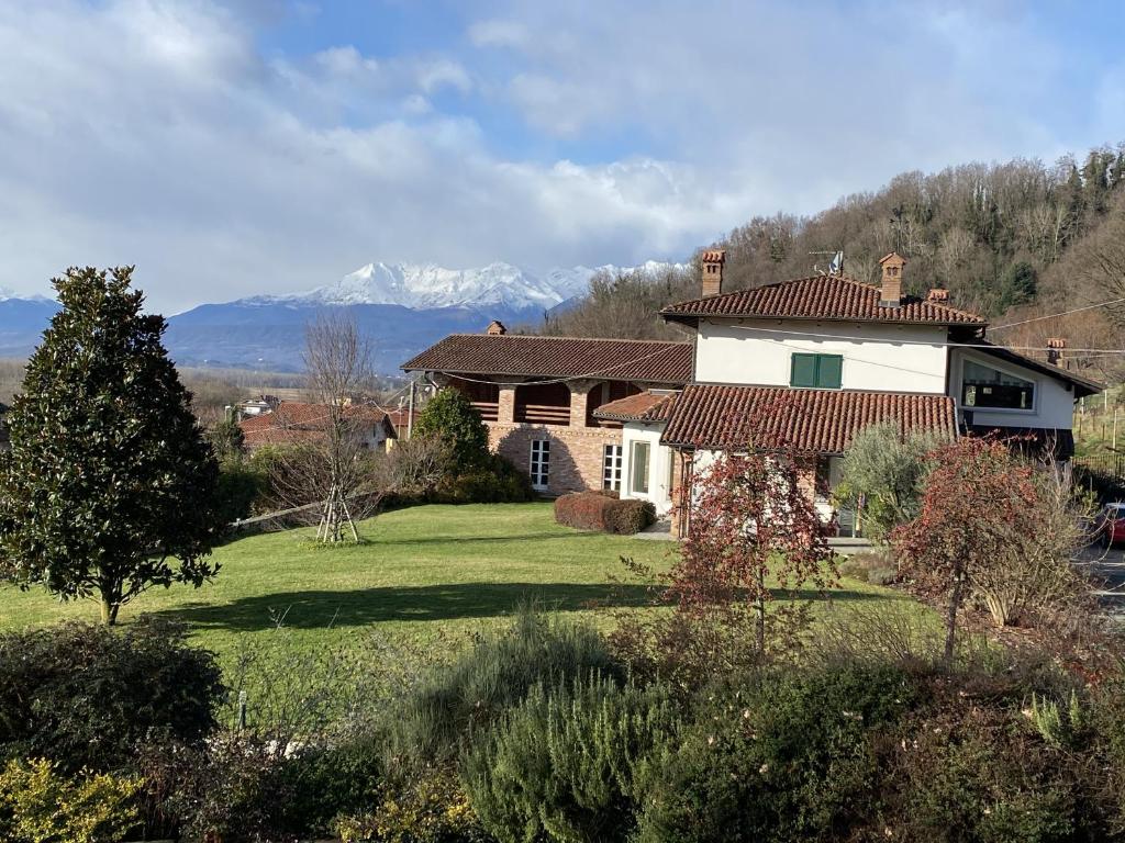 een huis in een veld met bergen op de achtergrond bij MyVilla B&B in Palazzo Canavese