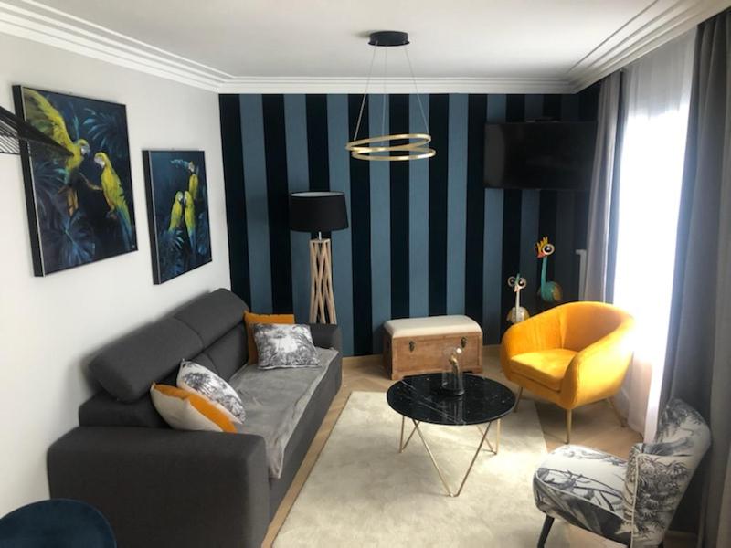 uma sala de estar com um sofá e uma cadeira em Appartement Chez Bernadette à 50m de la plage em Saint-Cast-le-Guildo