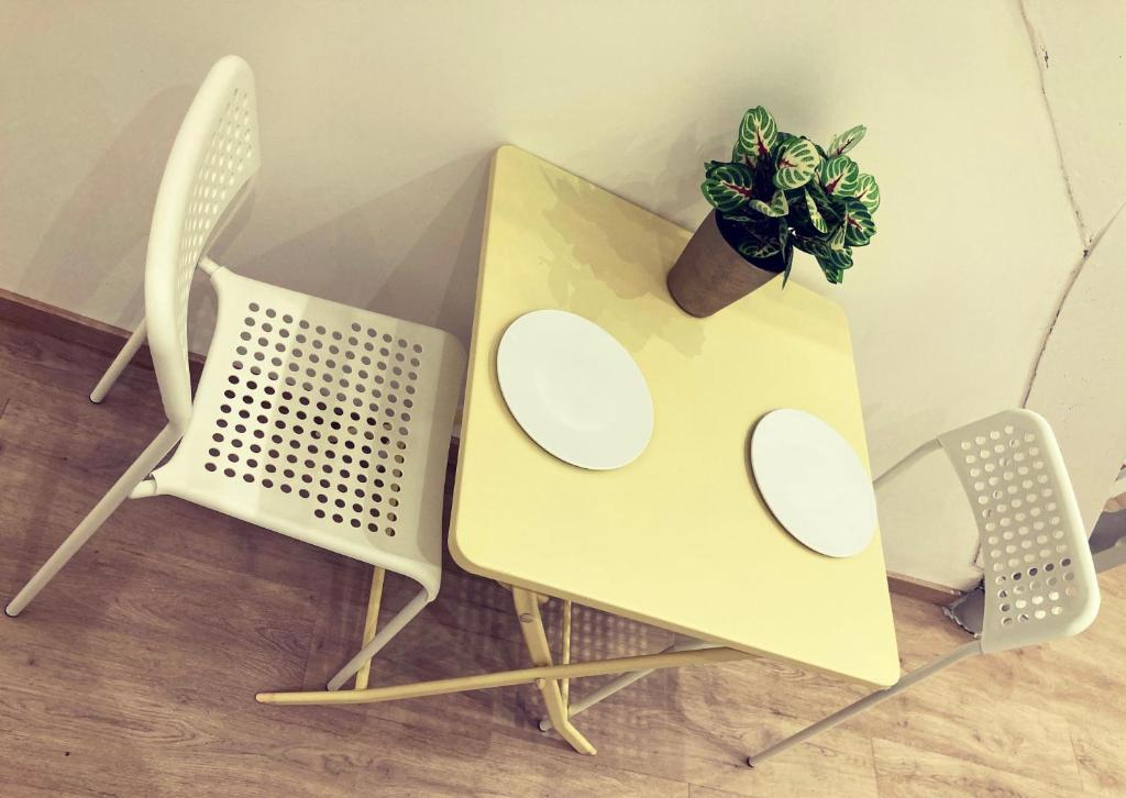 uma mesa com duas cadeiras e um vaso de plantas sobre ela em Benny's Rooms Brussels City Centre em Bruxelas